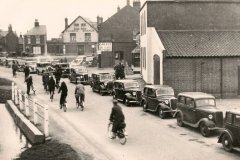 1938. Cars queuing  outside Francis' shop whilst on the way to see the Horsey floods.