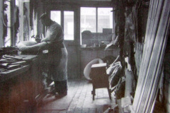 Harry Cobb, Harness maker, in his workshop at The Boot Store, The Green, c1921.  In the background can be seen the Ace Stores owned by Mr Francis